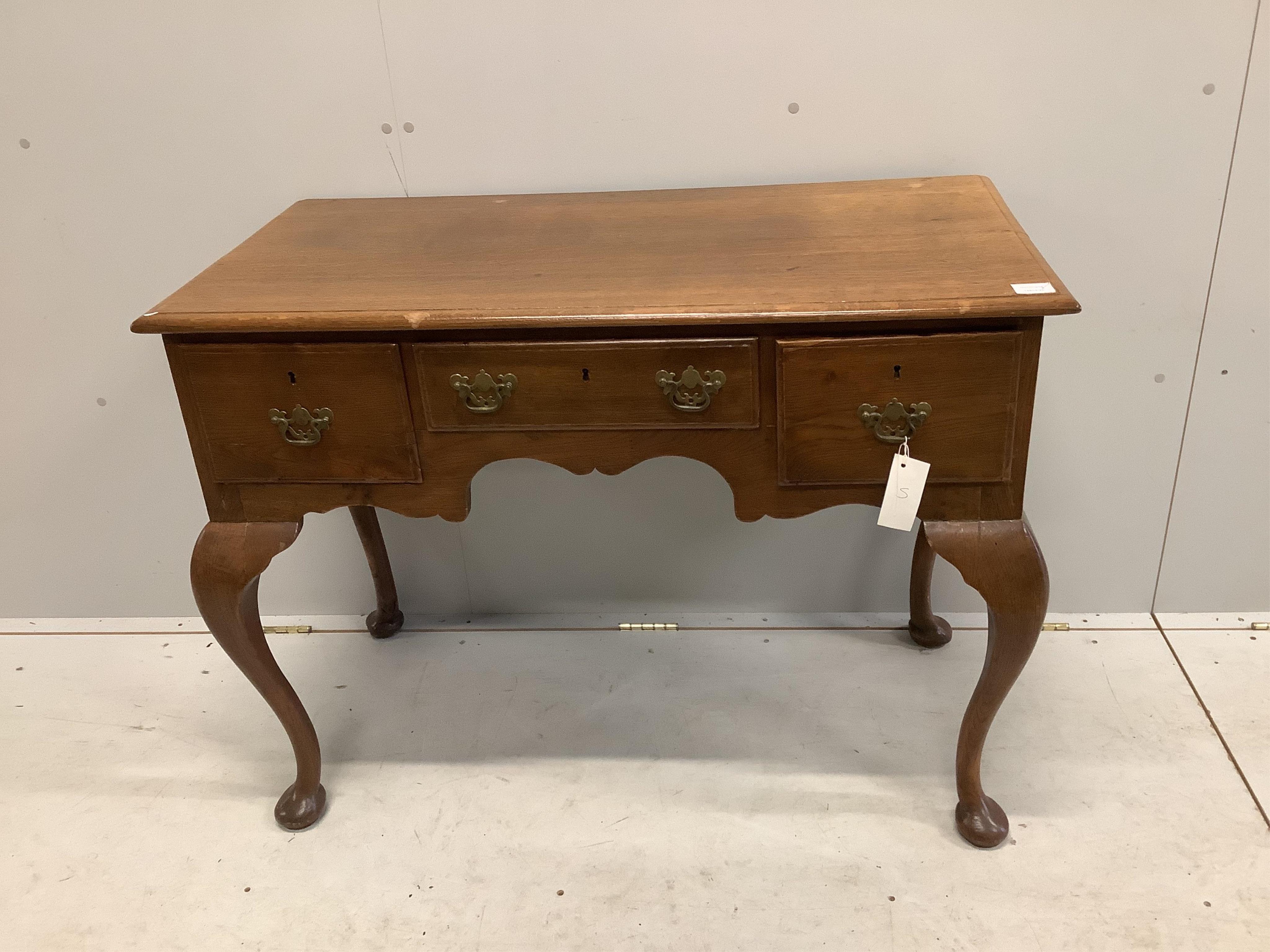 An 18th century style oak kneehole dressing table on cabriole legs, width 105cm, depth 53cm, height 78cm. Condition - fair, heavily chipped